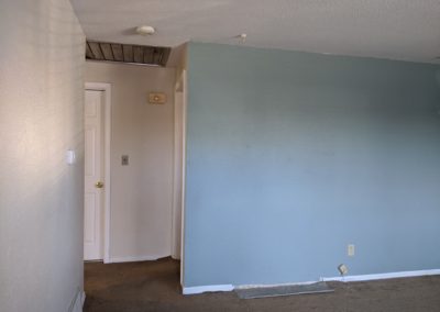 Hallway, wall, dirty carpet with mismatched patch