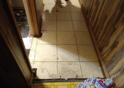 3 different damaged floors where laundry room bathroom and hallway meet