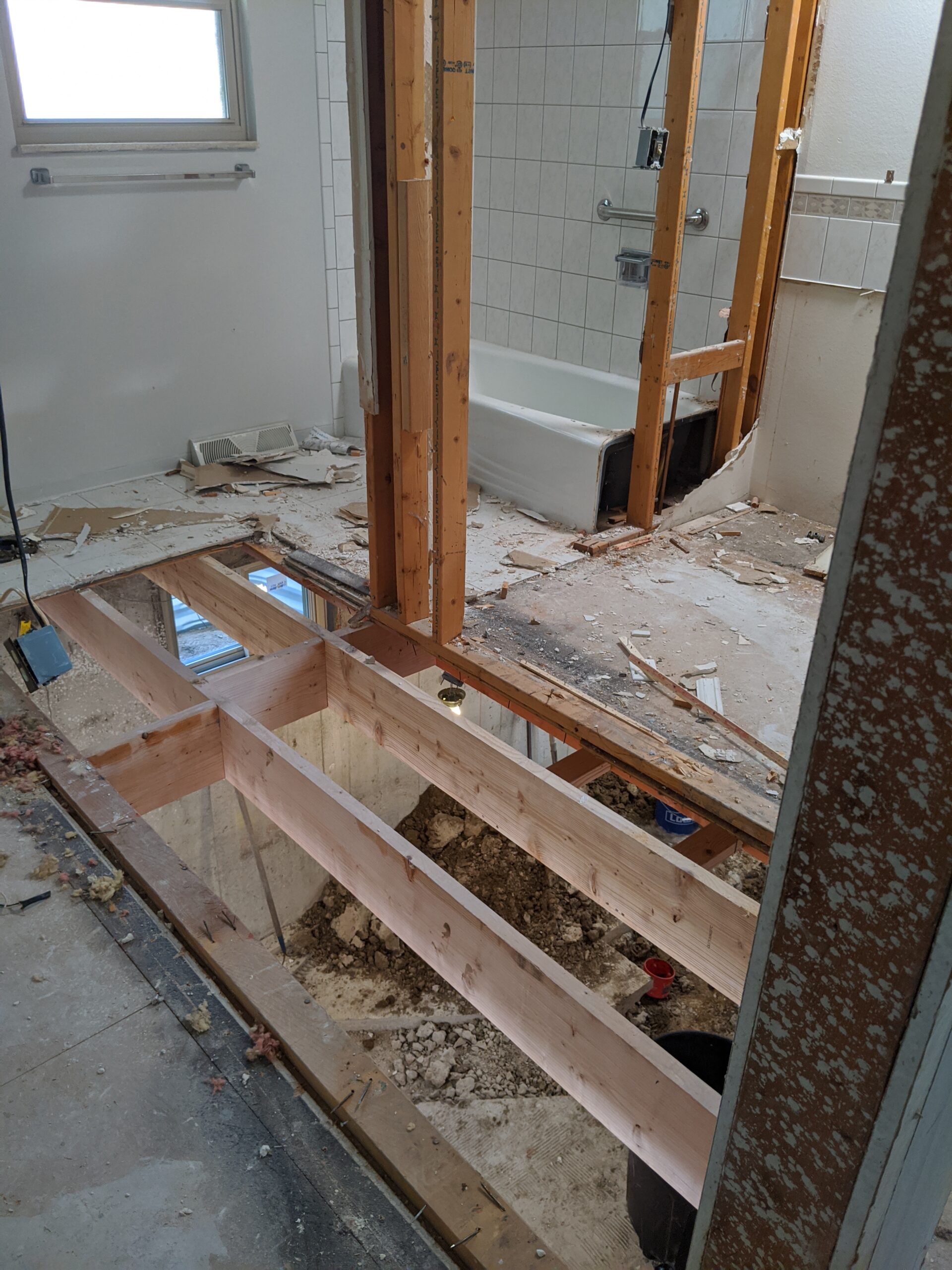 IN PROGRESS: Josh added floor joists beneath the hole in the stair’s original location to reinforce the subfloor in our future master bathroom.