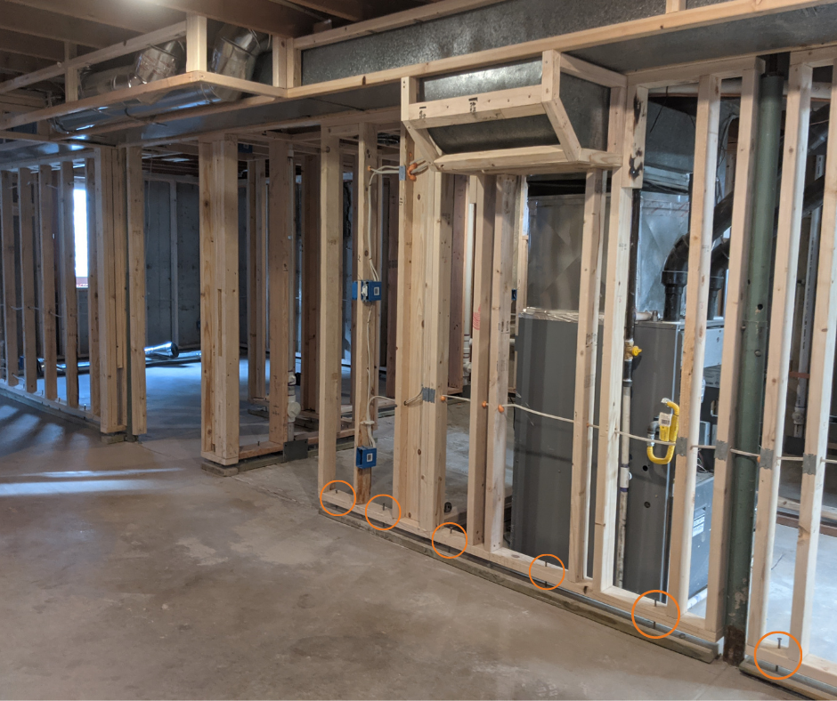 IN PROGRESS Bolts, circled in orange in the wall on the right, go through the bottom of the walls into the floor plate every 2 feet throughout the basement.