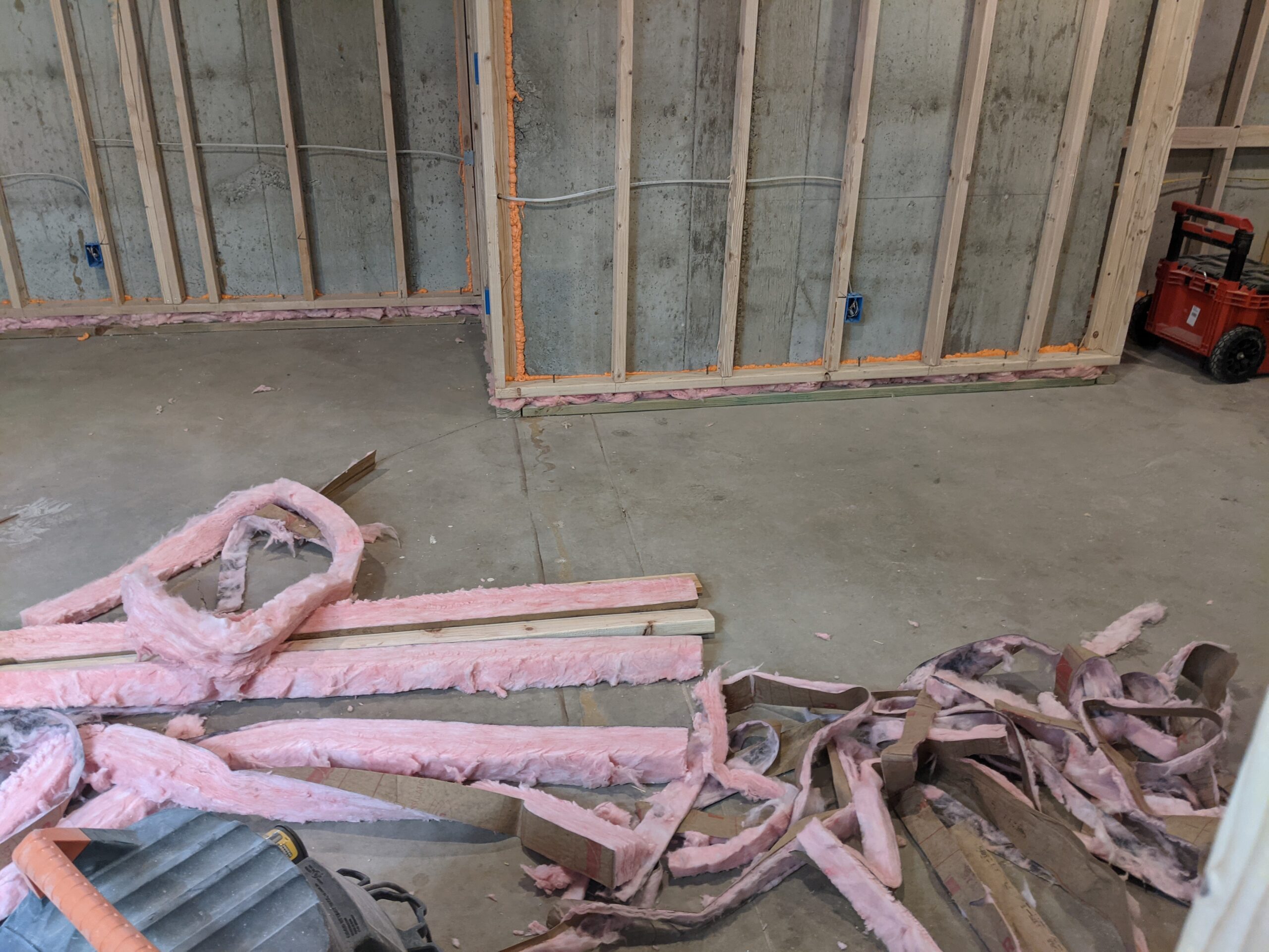IN PROGRESS We stuffed strips of pink insulation in the gap between the wall & floor plate and sprayed orange fire-blocking insulation vertically every 10 feet.