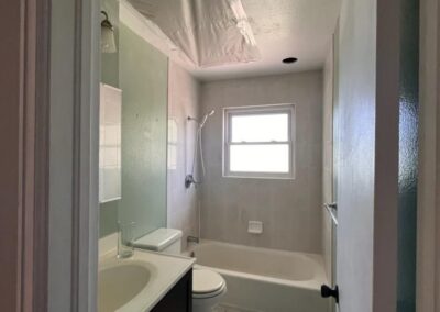 22. Home bathroom renovation in progress showing hole in ceiling cut by asbestos remediation company so contractors could safely install a new ceiling fan.