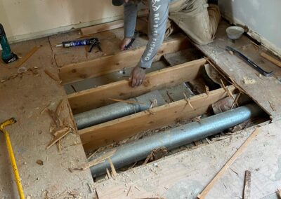 Subfloors in home kitchen are being replaced, heating ductwork can be seen between floor joists