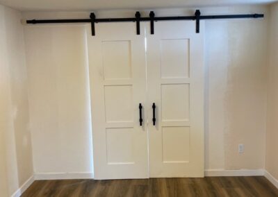 Barn doors and plank flooring in basement remodel