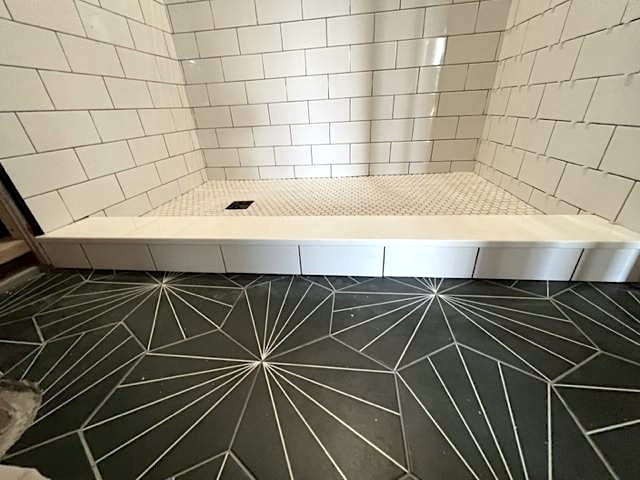 During basement bathroom remodel subway tile shower and black embellished floor tiles