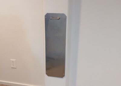 Custom metal access panel to home water line in basement remodel