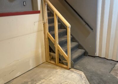 Installation of stair railing in basement restoration remodel