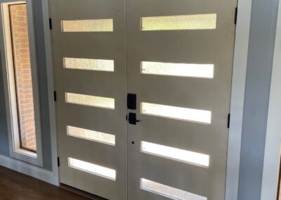 Interior view of modern double entry doors with horizontal frosted glass panels, surrounded by standalone windows.