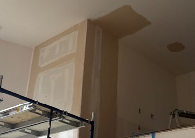 Loft wall with fresh drywall mud application, smoothing out seams during finishing stage of renovation.