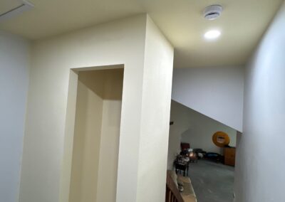 Framed and drywalled linen closet with no doors installed, showing progress during a hallway renovation project.