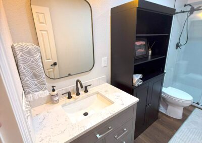 Basement bathroom vanity with modern lighting and marble countertop