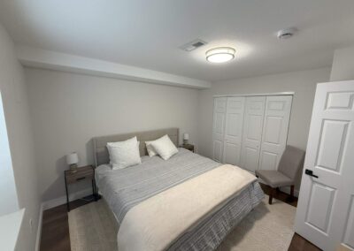 Cozy basement bedroom with upholstered bed and neutral décor