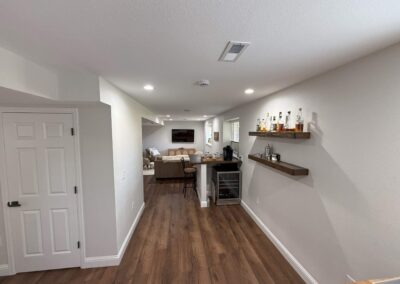 Basement home bar with floating shelves and seating